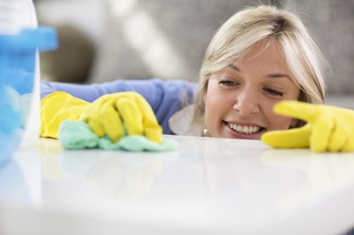Technician carefully cleaning fabric upholstery on a sofa in EC2